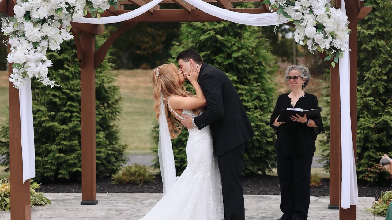 Haylee and Anthony sharing a kiss during their outdoor ceremony