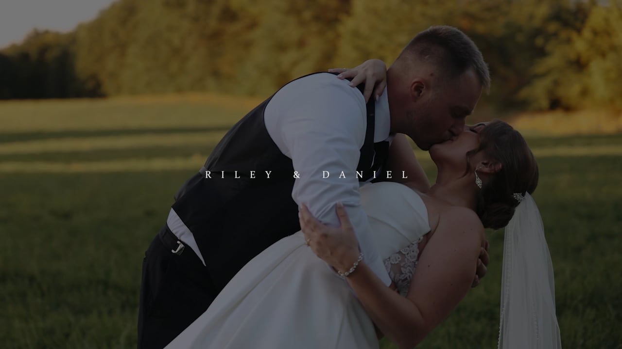 Riley and Daniel embracing in a sunlit field